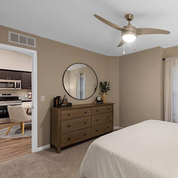 a bedroom with a bed, dresser, and mirror.