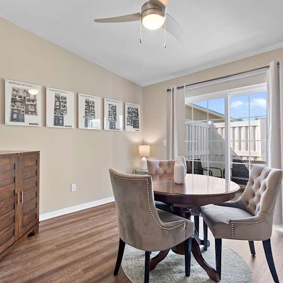 a dining room with a table and chairs and pictures on the wall.