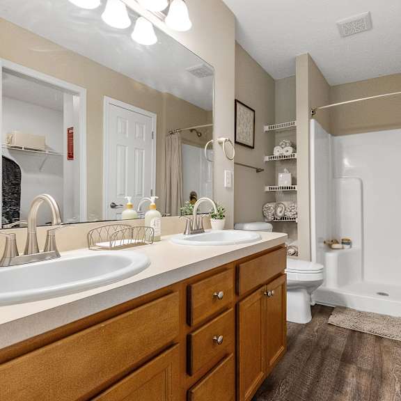 a bathroom with a double sink vanity and a walk-in shower.