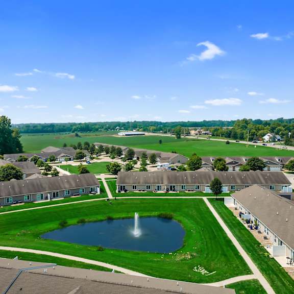 a bird's eye view of a housing complex with a pond in the middle.