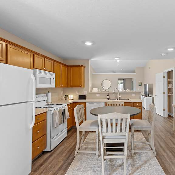 a kitchen with white appliances and wooden cabinets.