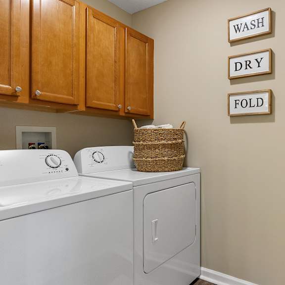 a laundry room with a washer and dryer and a sign that says "wash dry fold".