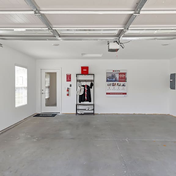 a large empty room with a fire extinguisher on the wall.