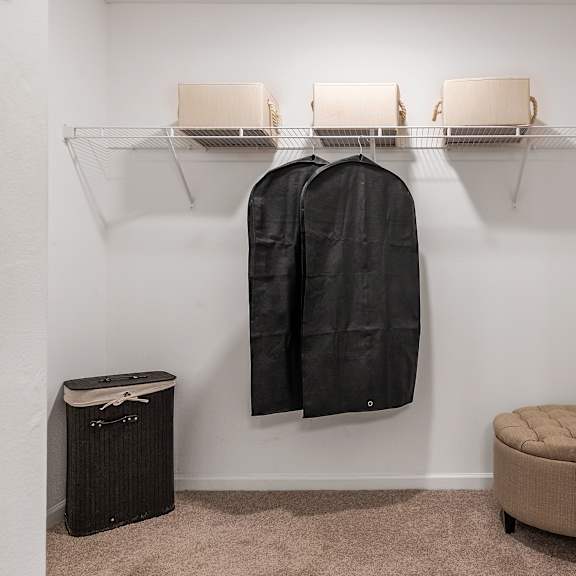 a black coat hanging on a rack in a room.