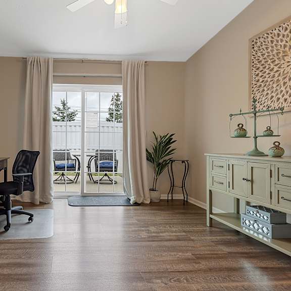 a room with a desk, chair, and a painting on the wall.