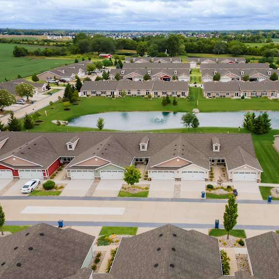 a bird's eye view of a residential neighborhood with houses and a lake.