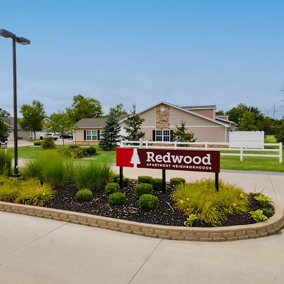 a sign for redwood is in the front yard of a house.