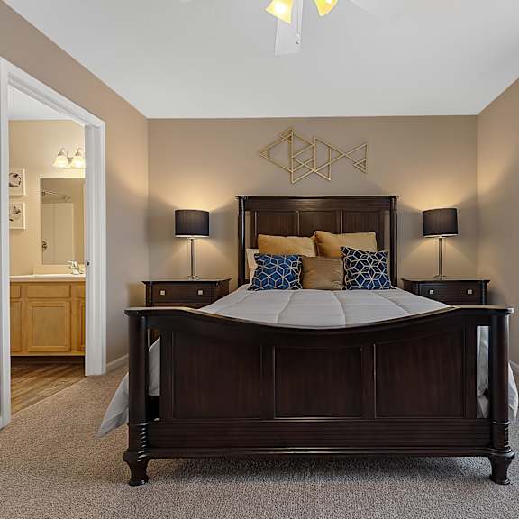 a bedroom with a large bed and two lamps.