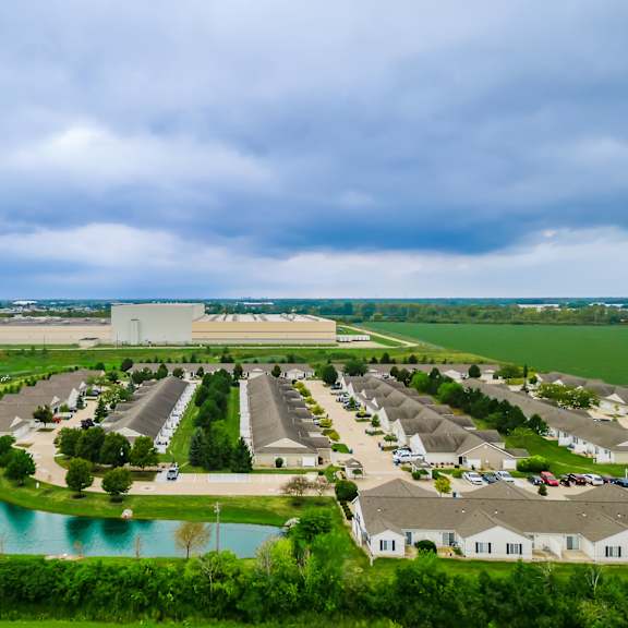 a large housing development with a pond in the foreground.