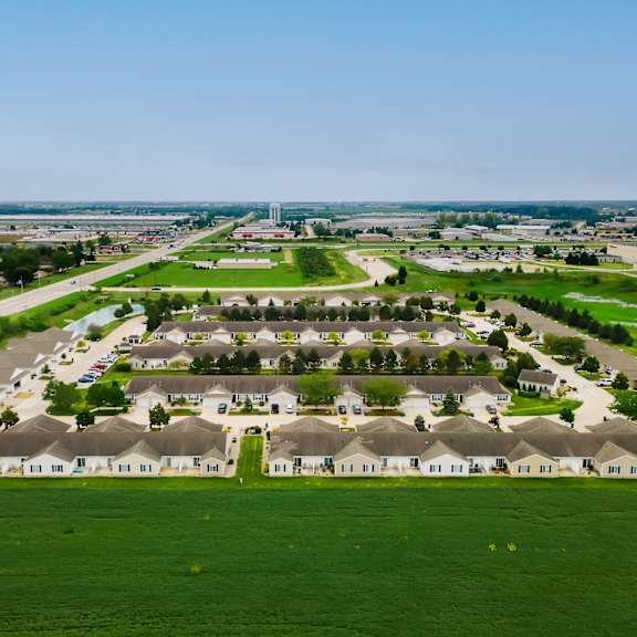 a large housing development with rows of houses and green lawns.
