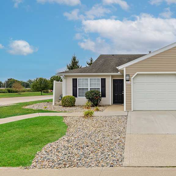 a house with a grey roof and two garages.