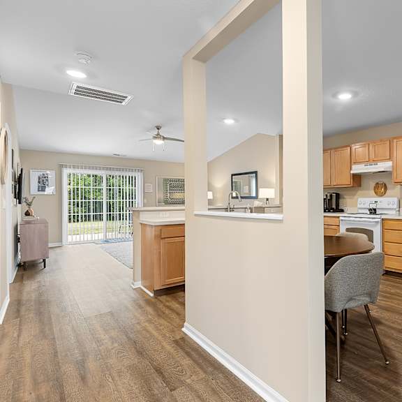 a kitchen with a white refrigerator and wooden floors.