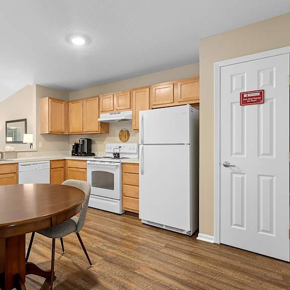 a kitchen with a table and chairs and a refrigerator.