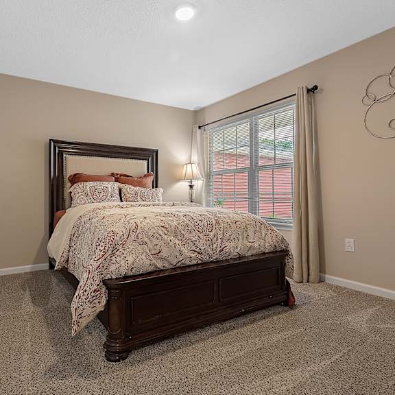 a bedroom with a large bed and a window with curtains.