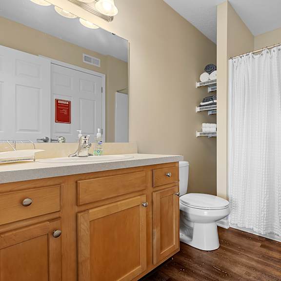 a bathroom with a toilet, sink, and shower.
