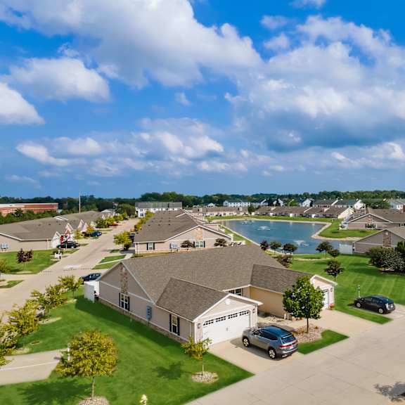 a suburban neighborhood with houses and cars parked in front.