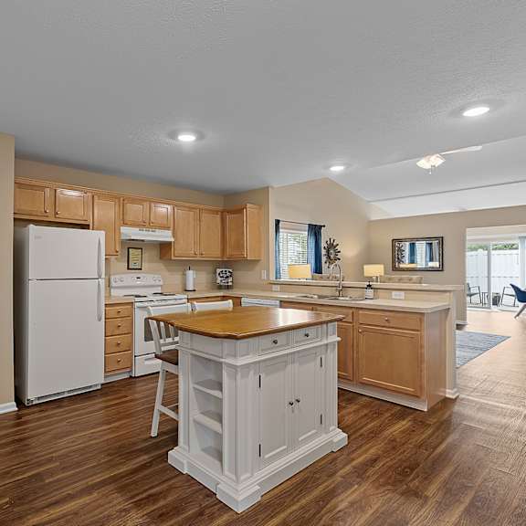 a kitchen with wooden floors and white appliances.