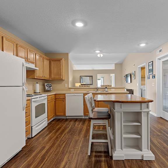 a kitchen with wooden floors and white appliances.