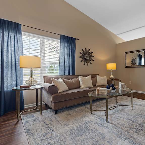 a living room with a couch, a coffee table, and a mirror.