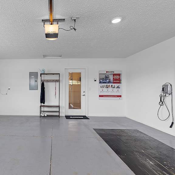 a spacious room with a door, window, and a wall-mounted hose reel.