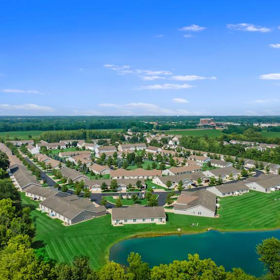 a bird's eye view of a residential area with houses and a lake.