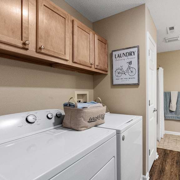 a laundry sign hangs above a washer and dryer in a small room.