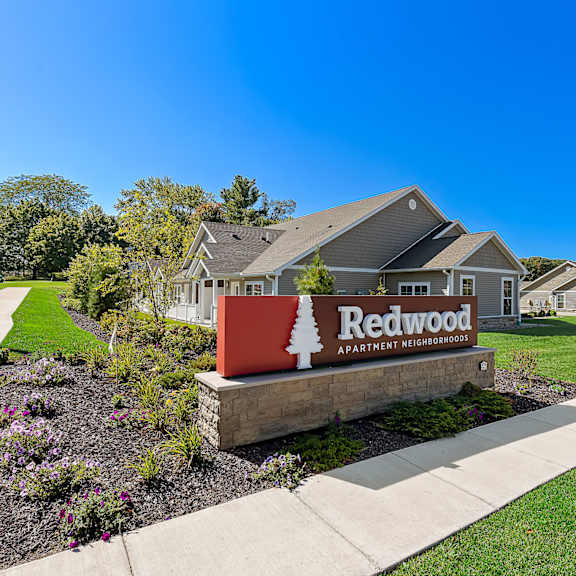 a sign for redwood apartment is in front of a building.