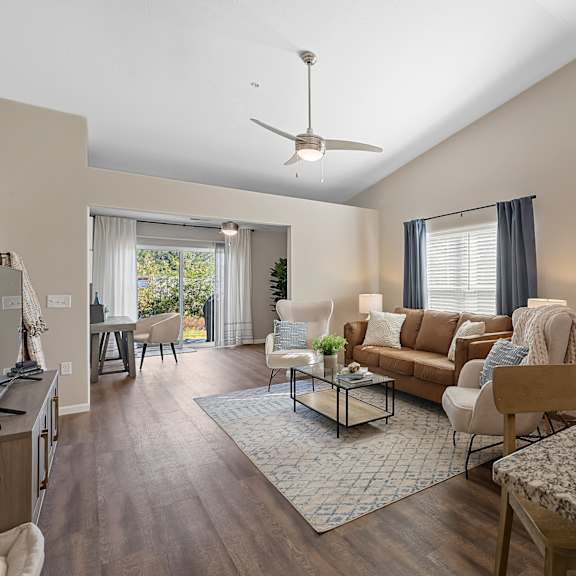 a living room with a ceiling fan and a large couch.