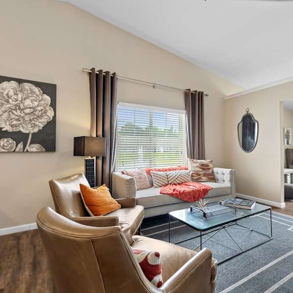 a living room with a brown leather chair and a glass coffee table.