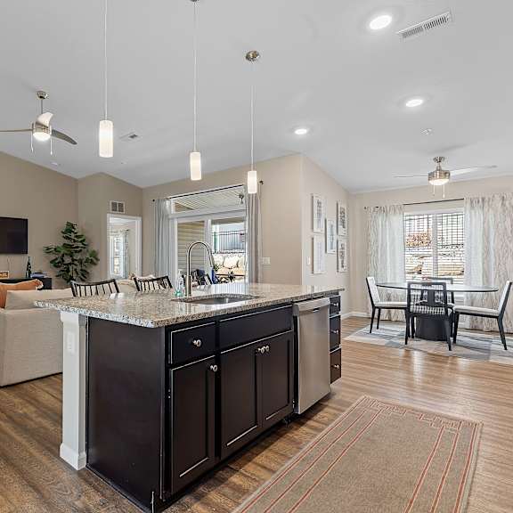 a modern kitchen with dark wood cabinets and a large island.