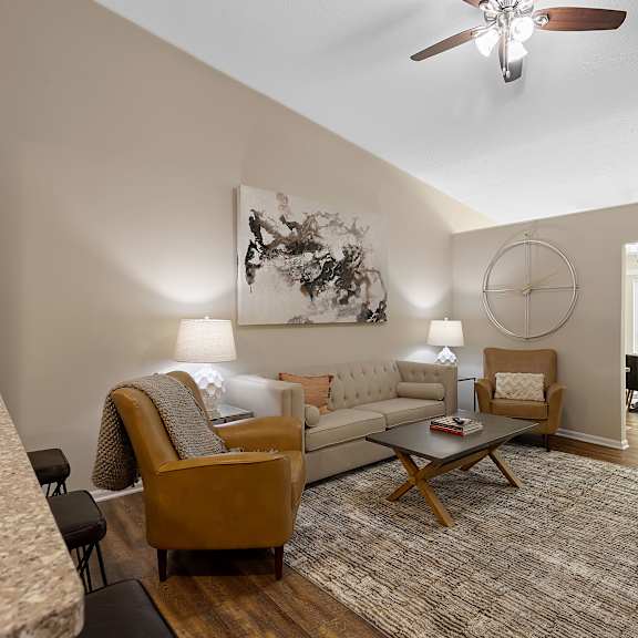 a living room with a couch, chairs, and a rug.