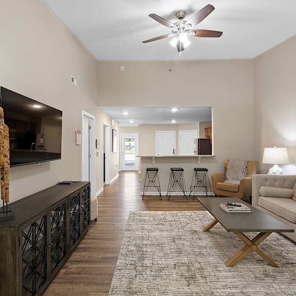 a living room with a television, couch, and bar area.