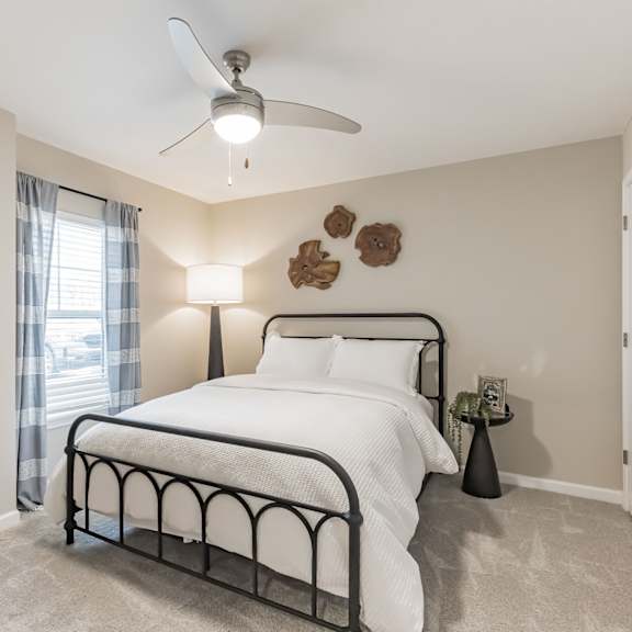 a bedroom with a large bed and a ceiling fan.