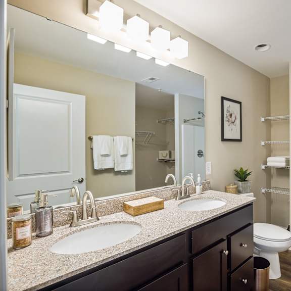 a bathroom with a white toilet, sink, and shower.