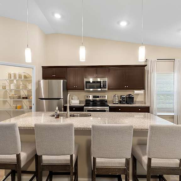 a modern kitchen with a center island and chairs.