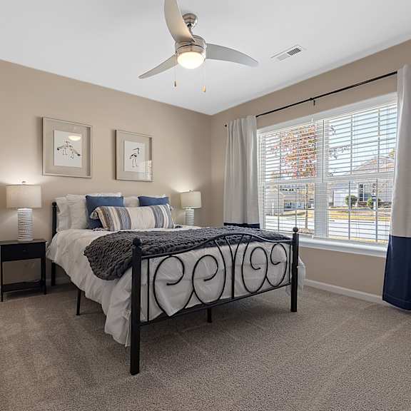 a bedroom with a bed, nightstands, and a ceiling fan.