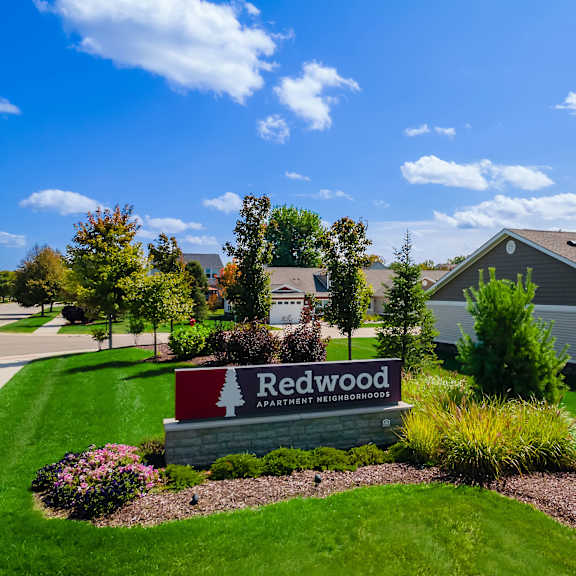 a sign for redwood apartment homes is in front of a building.
