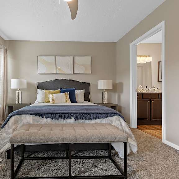 a bedroom with a bed, nightstands, and a ceiling fan.