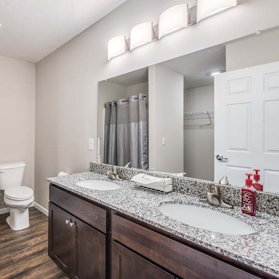 a bathroom with a toilet, sink, and mirror.