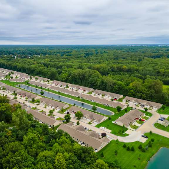 a bird's eye view of a residential area with houses and a lake.
