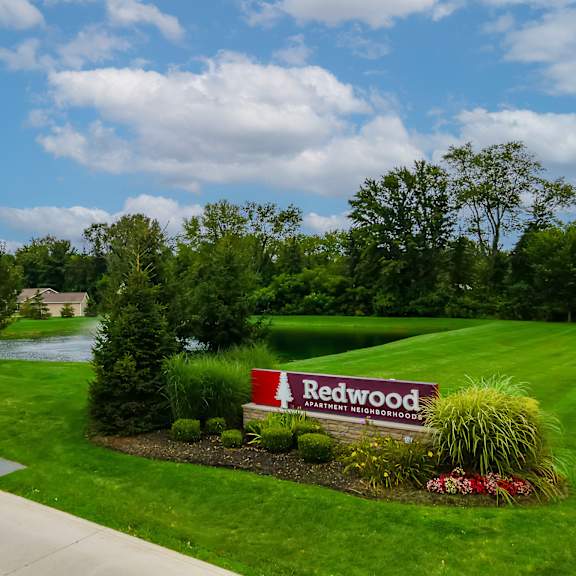 a sign that says redwood in front of a grassy area.