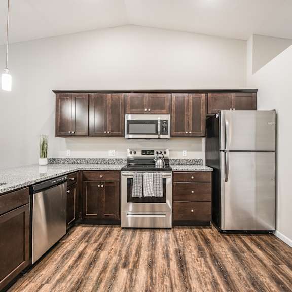 a kitchen with wooden floors and stainless steel appliances.