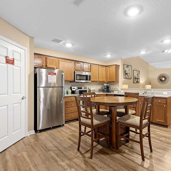a kitchen with a table and chairs in the middle of the room.