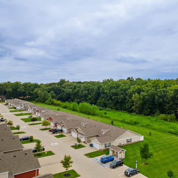 a row of houses with cars parked in front.