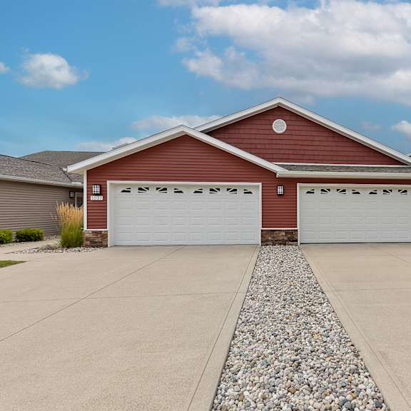 a red house with two white garage doors.