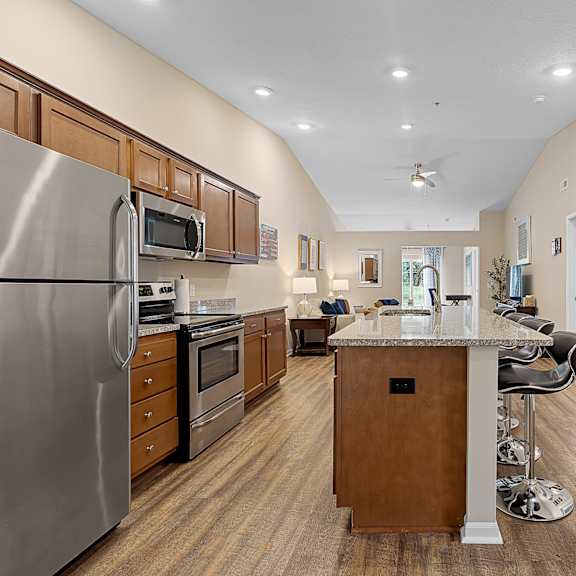 a modern kitchen with a center island and stainless steel appliances.
