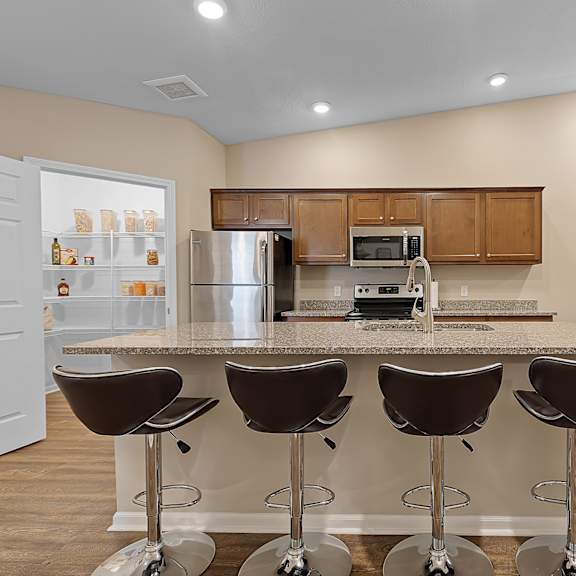 a kitchen with a bar area and a refrigerator.