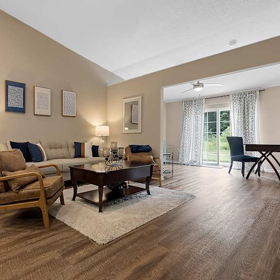 a living room with a wooden floor and furniture.
