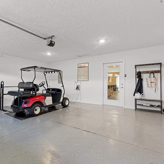 a red golf cart is parked inside a large, empty garage.