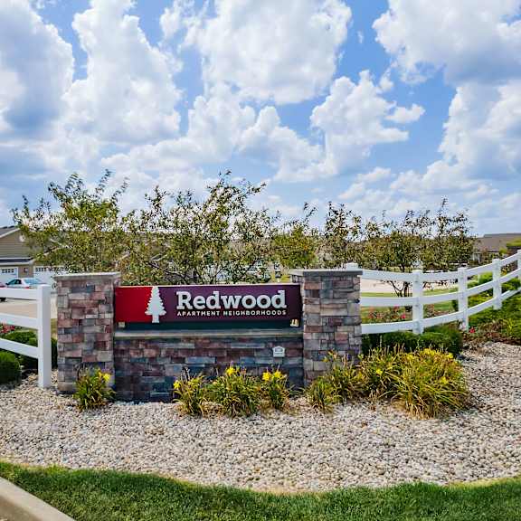 a sign that says redwood in front of a white fence.